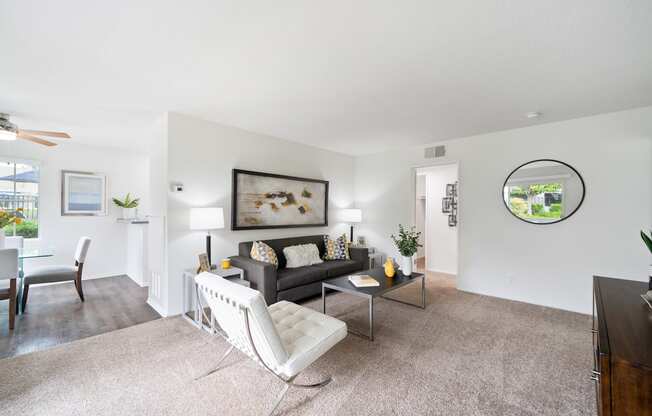 a living room with a couch and a chair and a dining room table