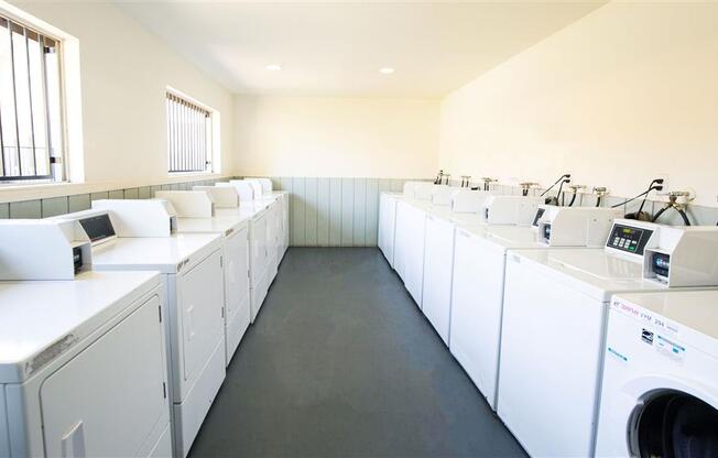 Laundry Center with Machines Next to Folding Counter at Courtyard at Central Park Apartments, California