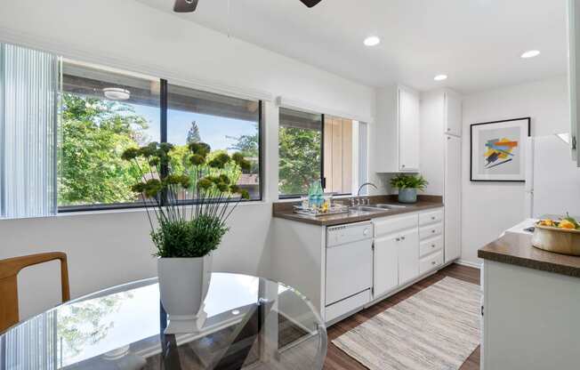 a kitchen with white cabinets and a glass table