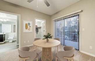 A dining room with a round table and four chairs.