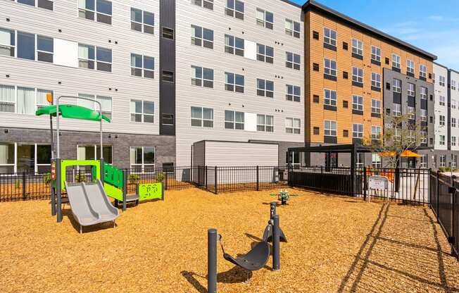 A playground with a green slide and a yellow slide.