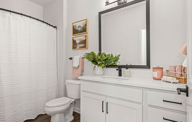 a white bathroom with a large mirror and a toilet