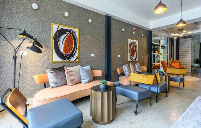 A modern living room with a grey sofa, a blue ottoman, and a yellow chair.