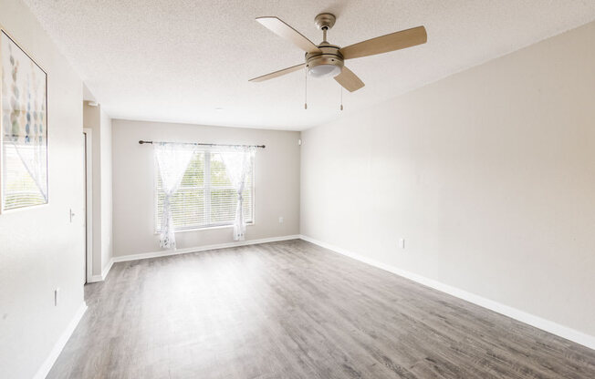 Empty living room with a ceiling fan_Rolling Hills Apartments