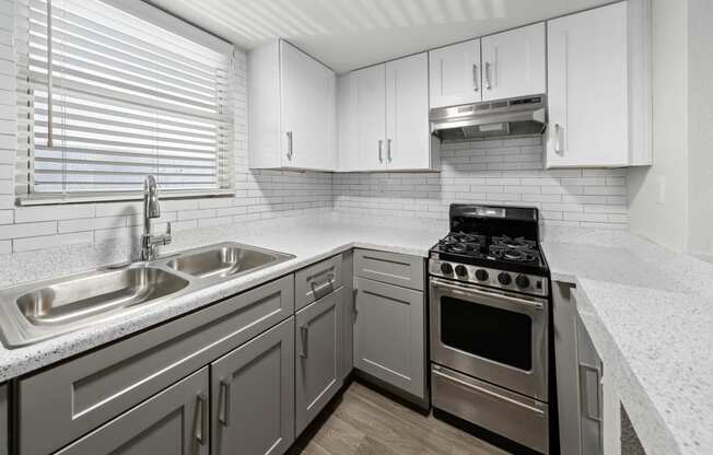 a kitchen with white cabinets and a stainless steel stove