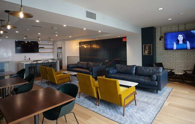 a living room with couches and chairs and a tv at The Commonwealth Building, Pittsburgh, 15222