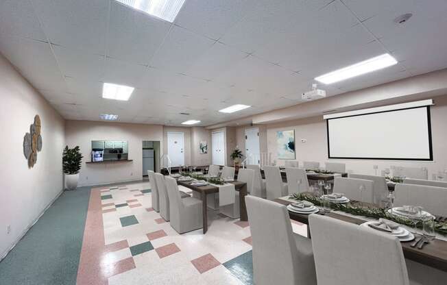 sample setup of the party room with tables and chairs and a projection screen