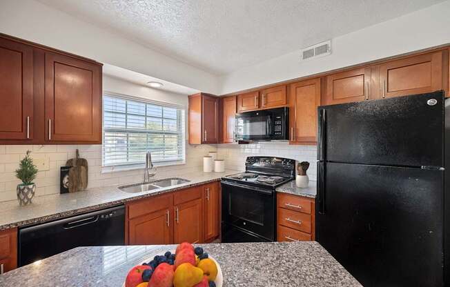 a kitchen with black appliances and granite counter tops