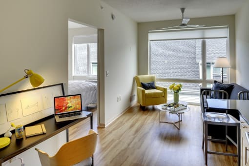 View of desk nook, living space and large window in the Flat E floor plan at Coze Flats