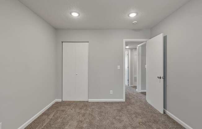 a bedroom with a carpeted floor and a door to a closet