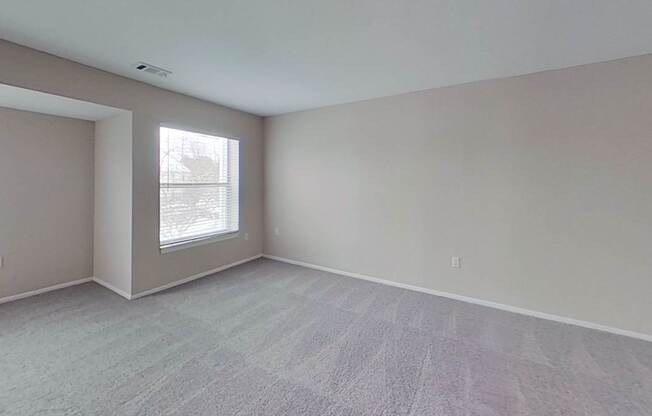 A room with a large window and a carpeted floor.