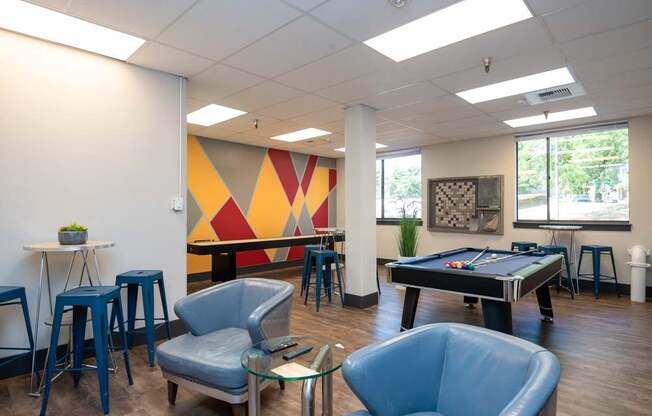 A room with a pool table and a bar area.