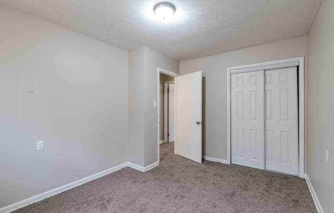 a bedroom with a white door and carpeted floor at Fay Street Apartments, Virginia, 22601