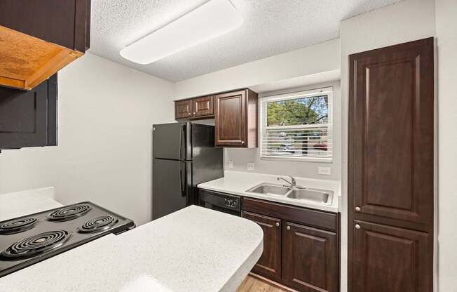A kitchen with a black stove top oven and a black refrigerator. at Montecito, Austin, TX, 78741