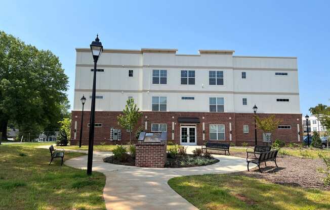 a brick building with a walkway and benches in front of it