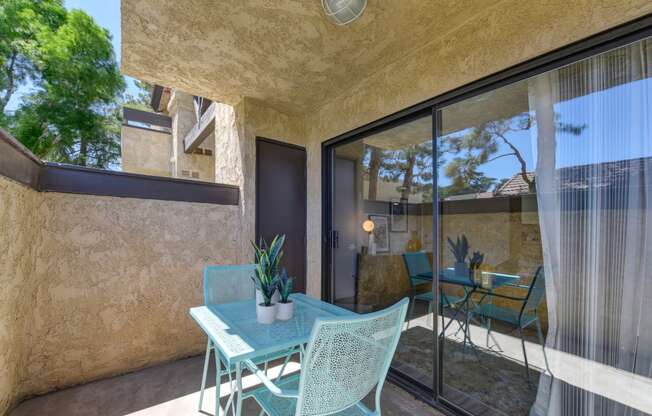 a patio with a table and chairs and a sliding glass door