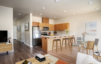 an open kitchen and living room with a bar and stools