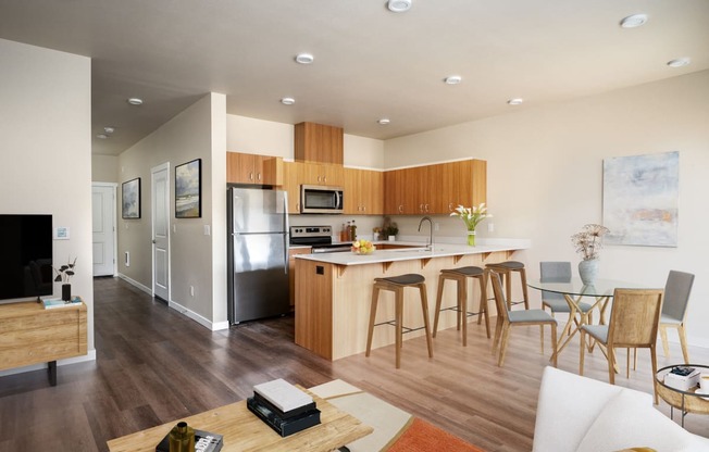 an open kitchen and living room with a bar and stools