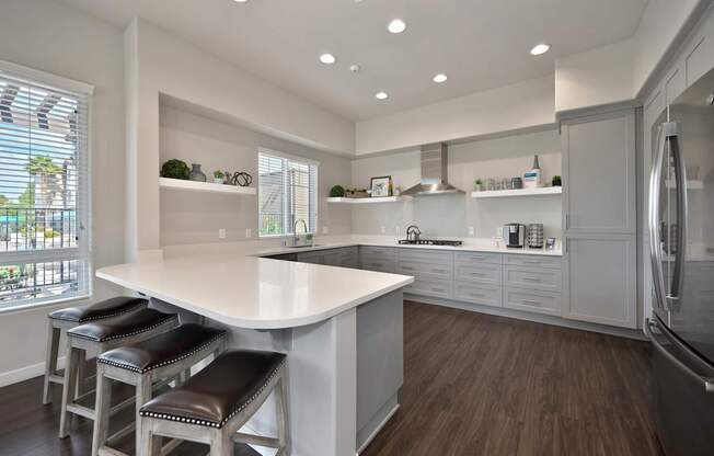 A kitchen with a white counter and brown stools.