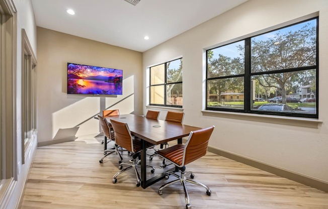 a conference room with a table and chairs and a large window
