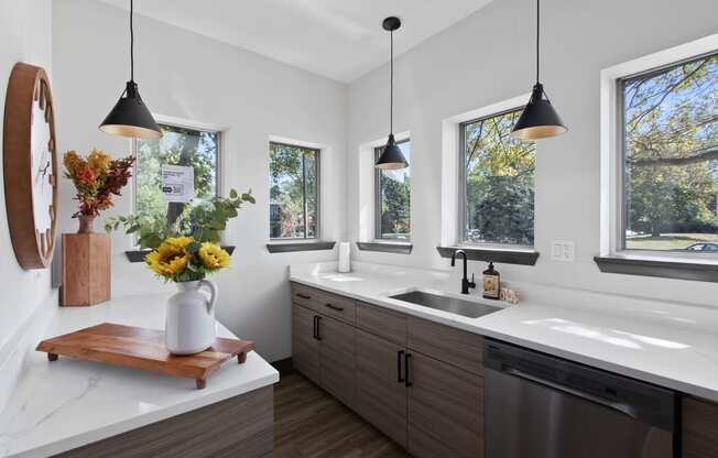 a kitchen with a sink and three windows