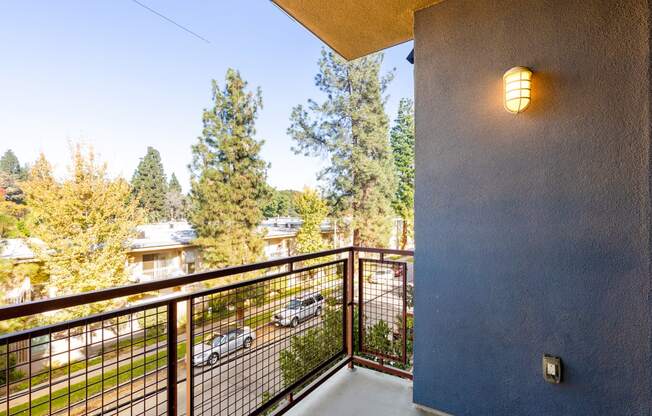 a balcony with a view of the street and trees