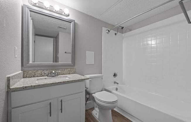 A bathroom with a white toilet, sink, and bathtub.