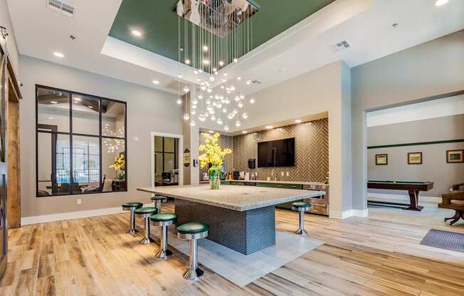 A modern kitchen with a bar area and a pool table.