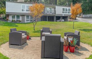 a patio with chairs and a table in front of a building