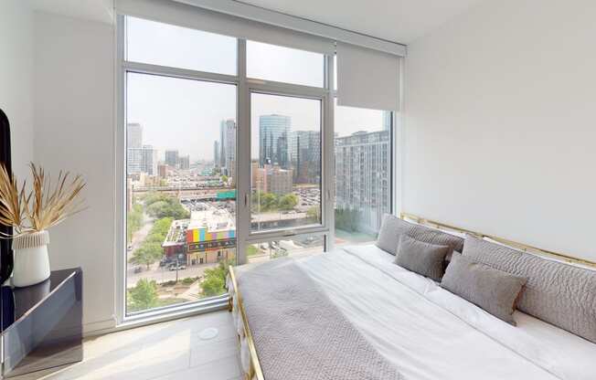 a bedroom with a bed and a large window