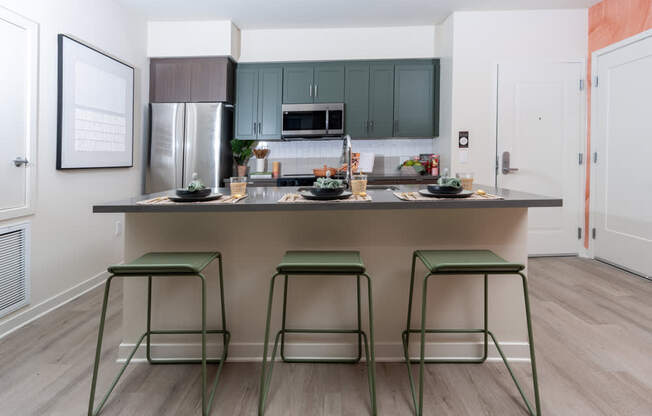 A kitchen with a bar stool in front of it.