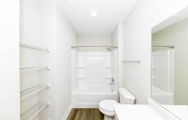 A white bathroom with a toilet, sink, and bathtub.