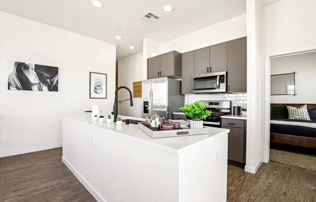 A modern kitchen with a white island and stainless steel appliances.
