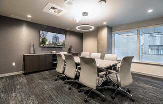 A conference room with a long table and chairs.