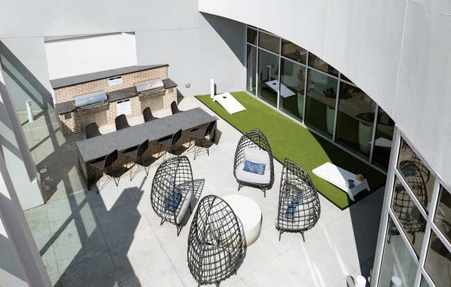 a courtyard with chairs and tables and a building in the background