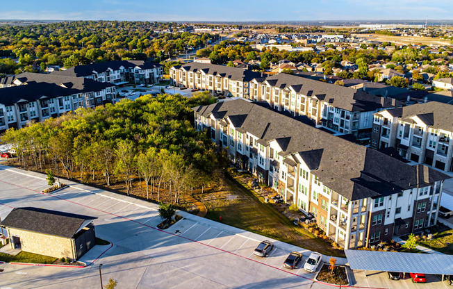 A large apartment complex with a parking lot in front.