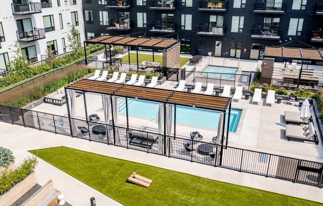 an aerial view of an apartment complex with a pool and lounge chairs