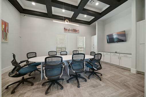 a room with a table and chairs and a flat screen tv on the wall