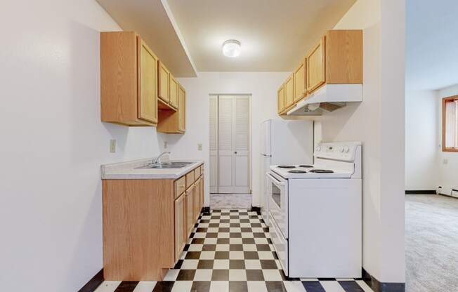 a kitchen with white appliances and a checkered floor