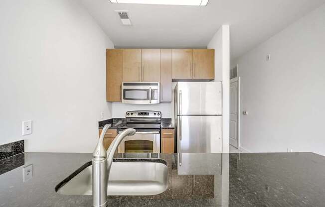 A kitchen with a sink, stove, and refrigerator.