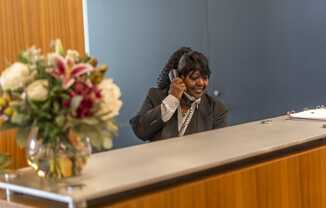 a woman sitting at a desk with a phone to her ear
