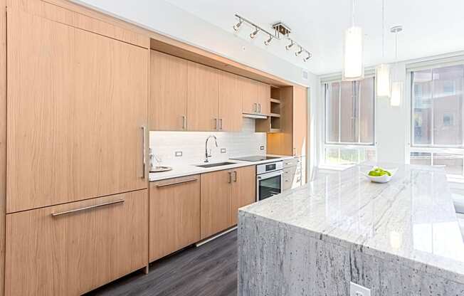 a kitchen with wooden cabinets and a marble counter top