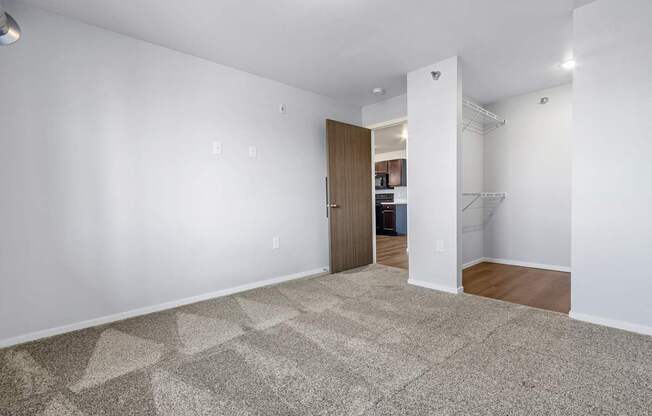 A room with a carpeted floor and a doorway leading to another room.