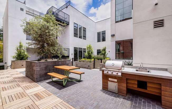 Outdoor kitchen has a grill and a picnic table at Edendale Crossing, 90026