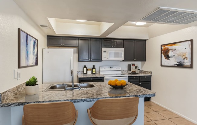 a kitchen with a counter top with two chairs and a sink