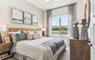 a bedroom with a bed and a large window