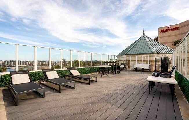 a rooftop deck with lounge chairs