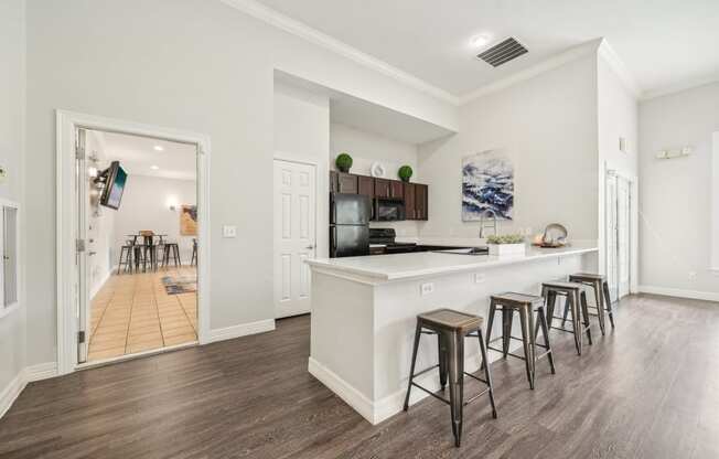 a kitchen with a white counter top and bar stools