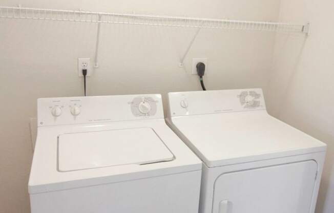 a white washer and dryer in a room with white walls