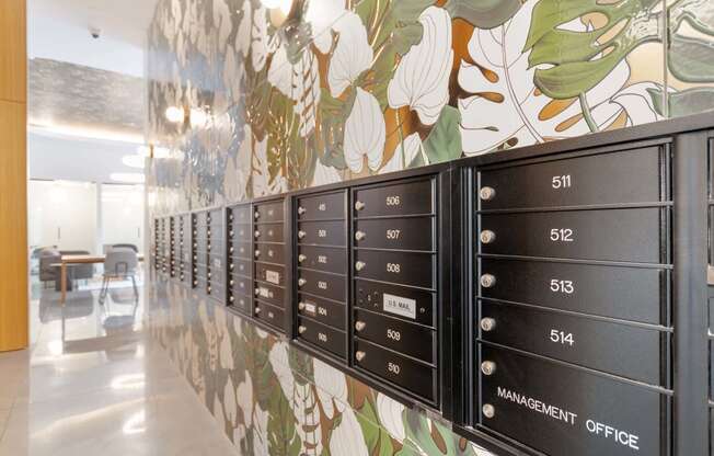 a long line of mailboxes in a room with a floral wallpaper